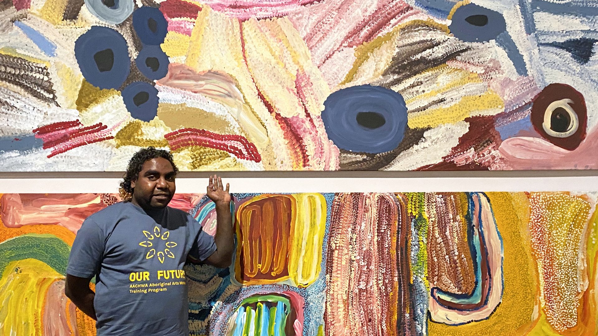 OUR FUTURE 2021 Aboriginal Arts Worker Trainee Corban Williams with Martumili painting at the Western Australian Museum. Photo: Glenda Dixon.