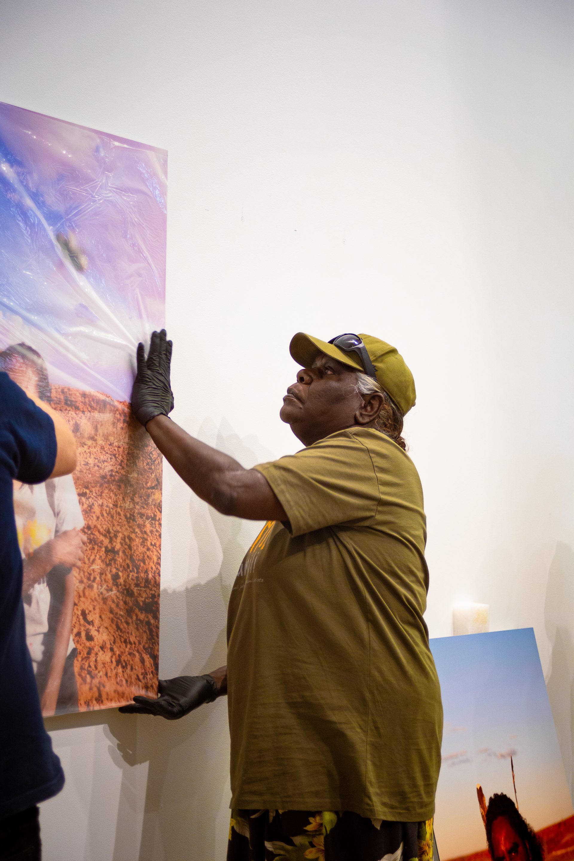 Angelina Boona helps to install artworks at the Martumili Gallery as part of Our Future: Aboriginal Arts Worker Training Program, Parnpajinya (Newman), 2023. Photograph by Jess Russell. 