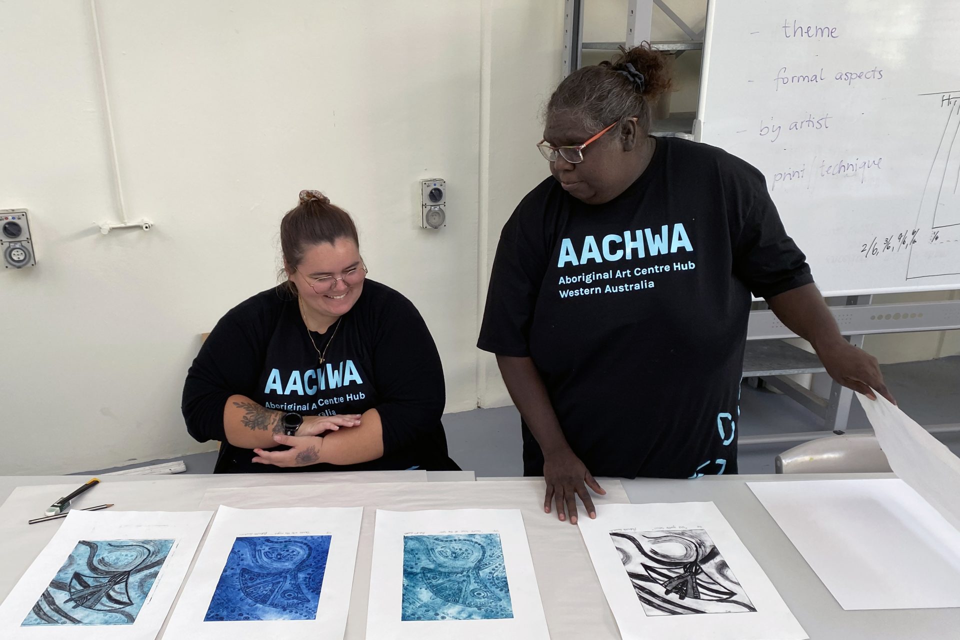 Rekeshia Goodwin and Julieanne Farmer discuss artwork placement for their exhibition planning at North Metropolitan TAFE studio, March 2024.