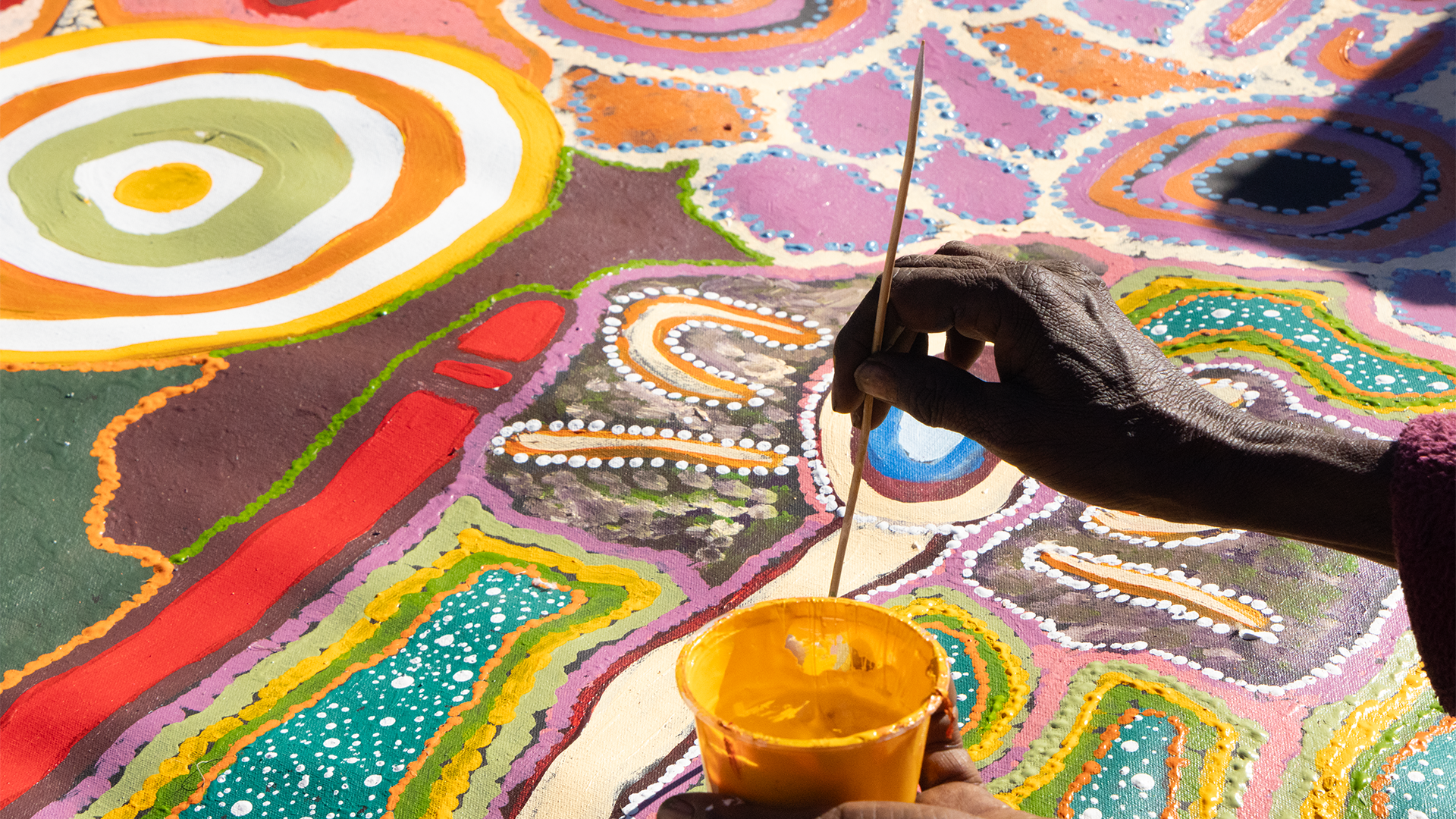 Detail of Hazel Roy painting on collaborative women's canvas at the Walka camp, Our Country Moves Program at Walka Camp, south of Kaltukatjara (Docker River), 2024. Photo by AACHWA. 