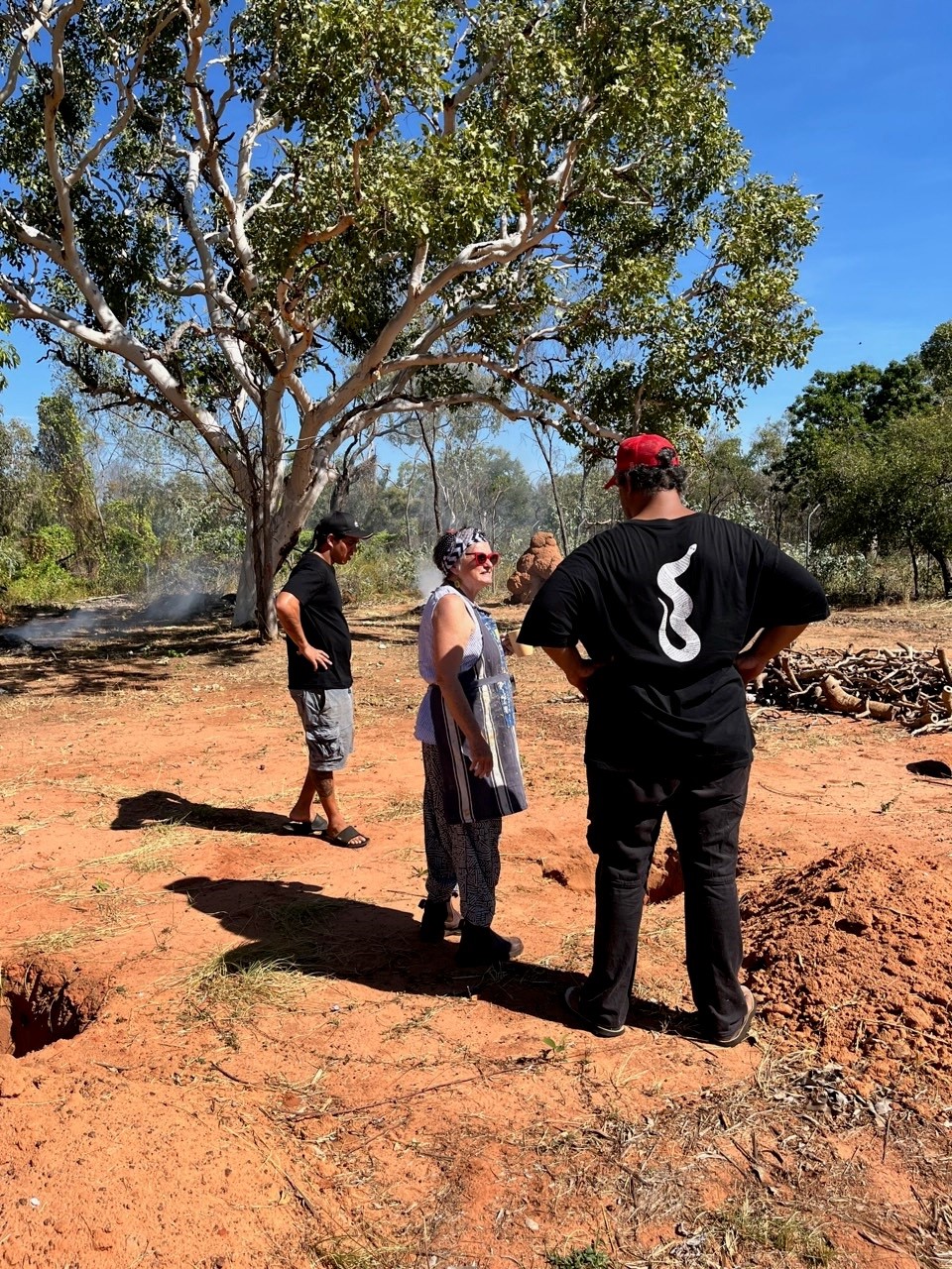 Robyn Lees and arts workers overseeing the rangers as they create fire pits for Raku firing, a traditional Japanese method of firing ceramics, at the Mowanjum Arts and Cultural Centre, Our Country Moves Program, (Derby), 2024. Photo by AACHWA