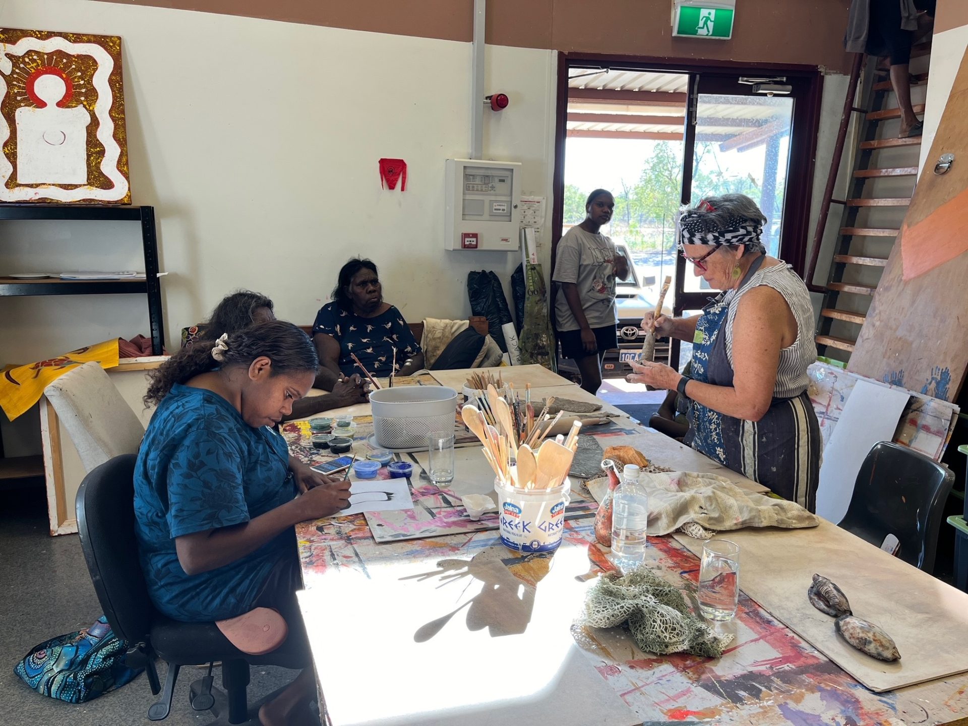 Artists from Mowanjum Arts and Cultural Centre working with facilitator Robyn Lees in the studio, creating vessels and sculptural forms, Our Country Moves Program, (Derby), 2024. Photo by AACHWA.